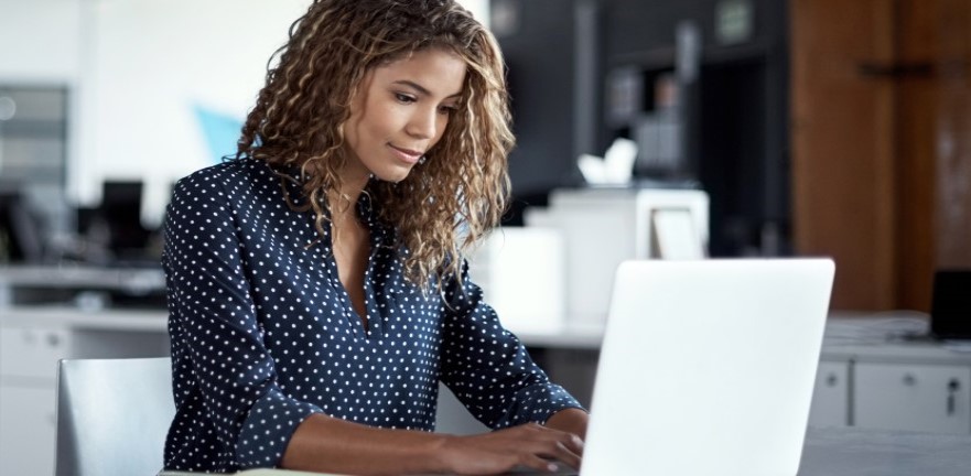 Women sitting at laptop and typing.